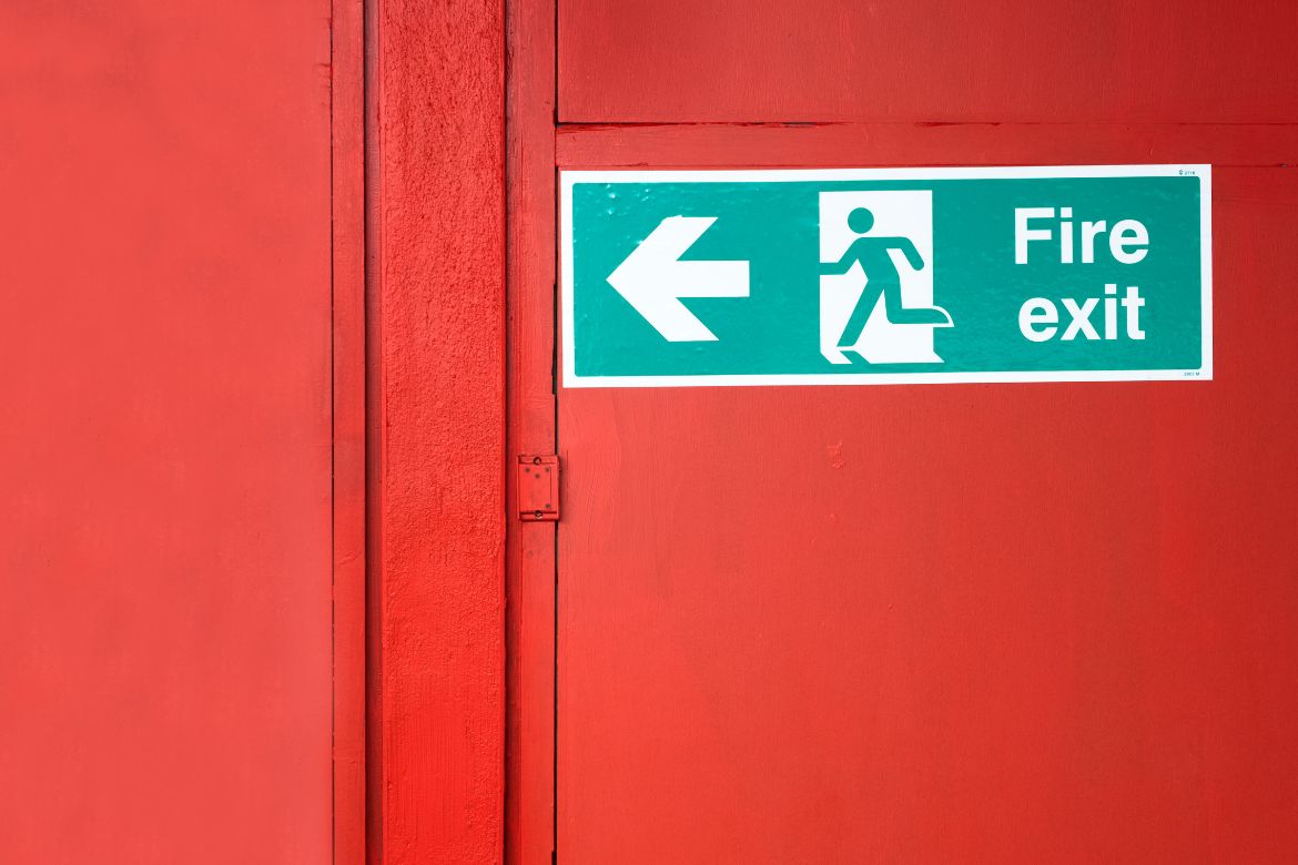fire exit sign on red door